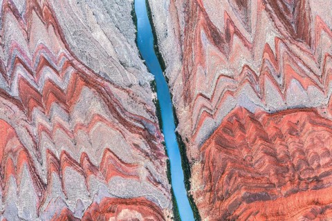 Stunning aerial shot capturing the Rio San Juan river flowing through vibrant striated rock