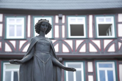 Sculpture of Saint Barabara, patron saint of miners, half-timbered fountain house, monochrome,
