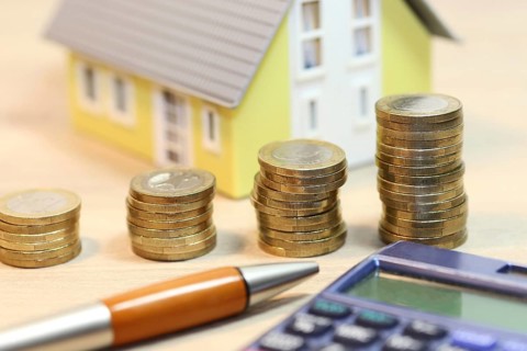 Concept photo with model house and coins