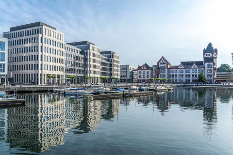 The Hörder Castle and modern office buildings on Lake Phoenix in Dortmund, North Rhine-Westphalia,