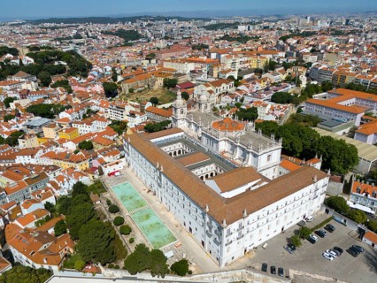 Monastery building in the middle of an urban landscape with red roofs and green trees in the