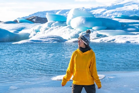 Portrait of a woman on the ice of the frozen lake Jokulsarlon during her vacation in Iceland