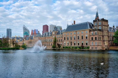 View of the Binnenhof House of Parliament and the Hofvijver lake with downtown skyscrapers in