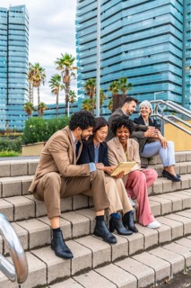 Vertical photo of a diverse group of business people working with digital tablet in the city