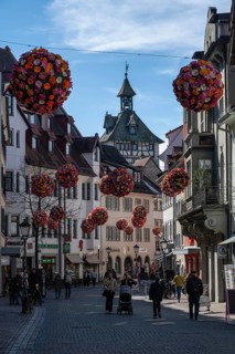 Street scene, busy pedestrian zone in the historic old town of Constance with spherical floral