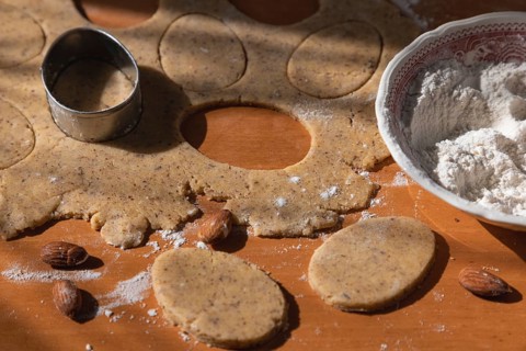 Dough with cut-out cookies in the shape of Easter eggs with a cookie cutter
