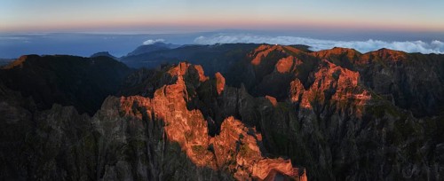 Aerial drone panorama view of Pico do Arieiro and mountains over clouds on sunset. Above Pico