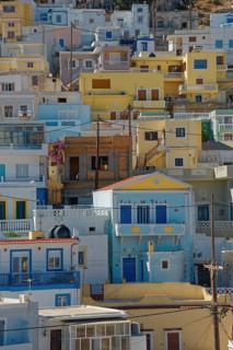 Densely built-up Mediterranean town of Menetes with pastel-coloured houses under a sunny sky,