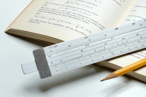 Slide rule on book, calculating aid