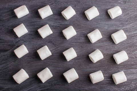 Set of marshmallows on black wooden background. top view, flat lay. geometric pattern