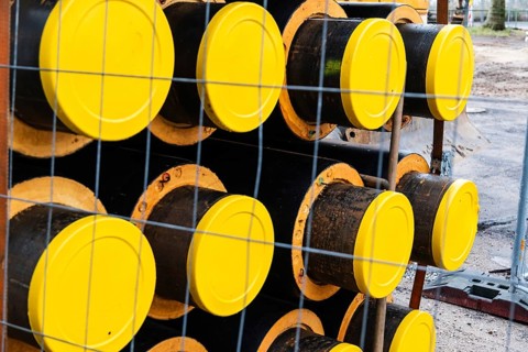 A stack of new pipes for a district heating pipeline on a construction site in Düsseldorf, Germany