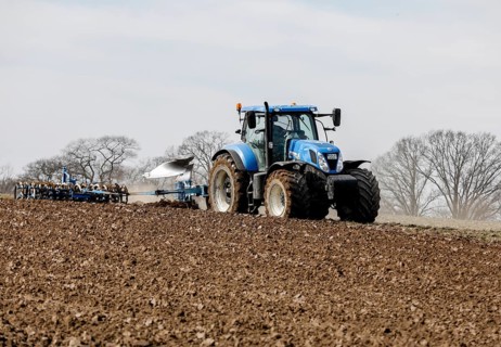 A tractor from the Jahnsfeld Biolandhof is pulling a seed furrow to sow gluten-free oats in the