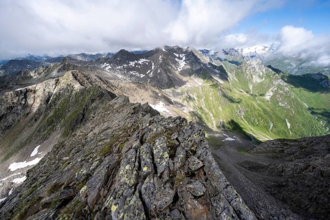 Steep rocky ridge, at the summit of the Lasörling, view of the mountain panorama of the Venediger