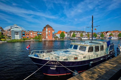 HAARLEM, NETHERLANDS, MAY 6, 2018: Spaarne river with boat moorned at quay in Haarlem, Netherlands