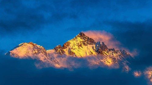 Snow-covered summit of the Weisshorn mountain, illuminated by the evening sun, view from Grimentz,