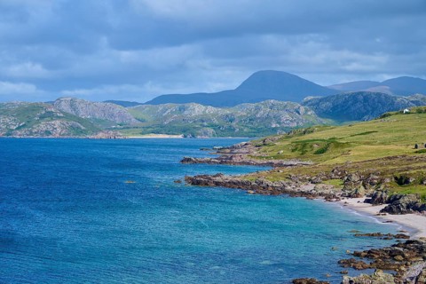 Rocks and hills form a picturesque coastline under a cloudy sky, Gruinard Beach, First Coast,