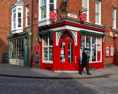 Post Office corner shop painted bright red, Eastgate, Bailgate, Uphill area of city of Lincoln,