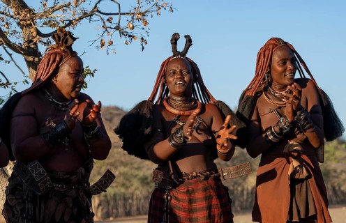 Traditional Himba woman clapping, music and dance, portraits, in the evening light, near Opuwo,