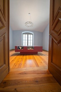 Simply furnished interior with a wooden floor and a modern table in front of a window, Weimar,
