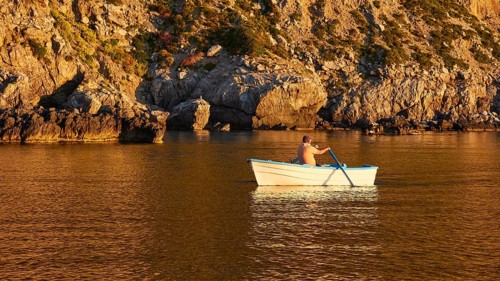 Rowing boat, man rowing, morning light, Marettimo, Egadi Islands, Sicily, Italy