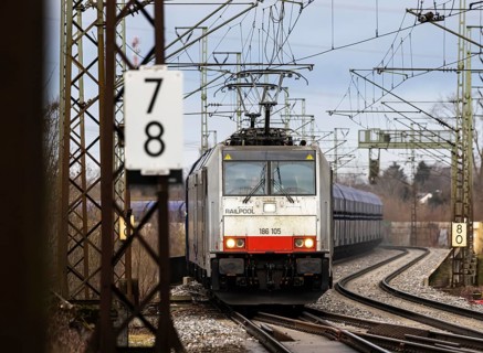 Goods train travelling on the winding Schuster Railway, overhead lines and infrastructure.