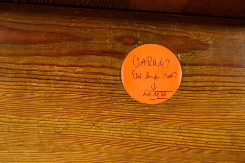 Why?, How much longer?, questions on a sticky note on a church pew with a Bible reference to