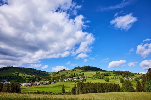 Landscape with hills, forest and meadow and blue sky with cumulus clouds near Bernau in the Black