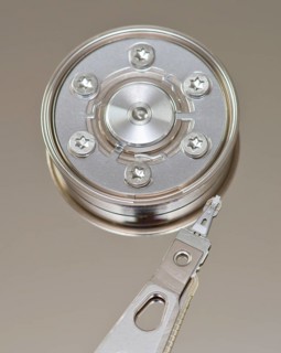 Detailed image showcasing a metallic hard drive arm positioned beside a circular platter,