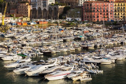 High angle view of marina with luxurious private yachts and sailboats bordered by apartment