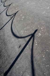 A street with the shadow of a fence