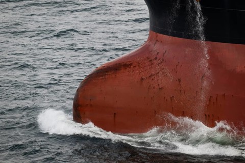 Close-up, bow of a tanker ship cuts through the sea and produces spray, overseas port, Rostock,