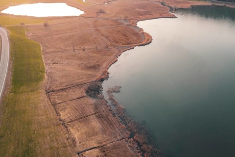 Aerial view of a coastline with adjacent road and agricultural area, Großer Alpsee, Immenstadt im