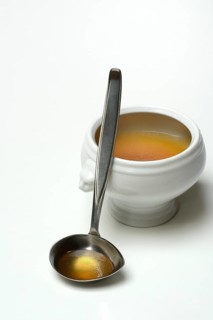 Bouillon, beef broth with ladle in bowl