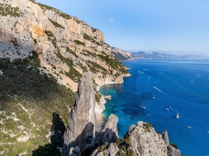 Picturesque rocky coast, cliffs with L'Aguglia pinnacle, blue sea and Cala Goloritzé beach, aerial