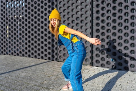 Young blonde woman dancing joyfully in casual clothes, expressing herself through urban dance