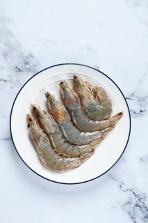 Fresh raw white-footed shrimp, tiger prawns vannamei, on a white plate