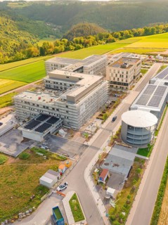 Large buildings in a hilly environment with solar panels, seen from the air, construction of the