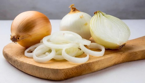 Vegetables, onion, Allium cepa, freshly sliced onion rings and finely chopped onion on a wooden