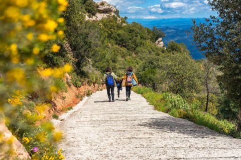 Family walking down a path in montserrat mountains, enjoying the scenic view and the natural