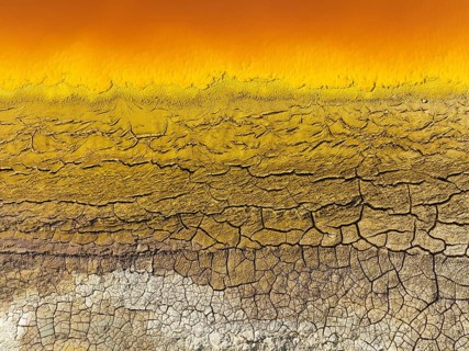 Cracked earth at the bank of the Rio Tinto (Red river) with its deep reddish hue due to oxidised