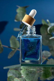 A refreshing face serum designed for men, contained in a stylish glass dropper bottle with a wooden