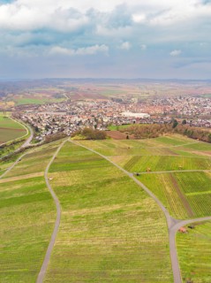 Village in a wide plain surrounded by fields under a partly cloudy sky, Großbottwar, Ludwigsburg
