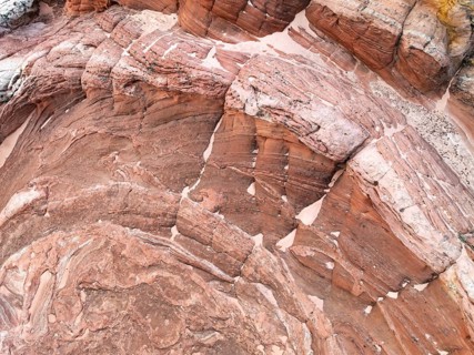 Captivating aerial view of textured red desert landscape, showcasing intricate layers and natural