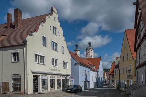 Historic houses, in the background the towers of the Catholic parish church of St Emmeram, Wemding,