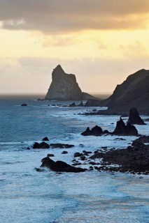 Beach of Playa de Benijo at high tide with the rock Roques de Anaga in the light of the rising sun,