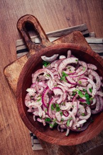 Chopped red onion, with sumac and herbs, in a bowl, pickled Spanish onion, close-up, top view