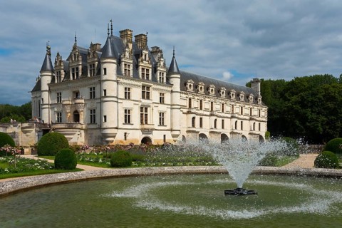 Majestic castle with manicured gardens and fountain on a slightly cloudy day, Chenonceau Castle,