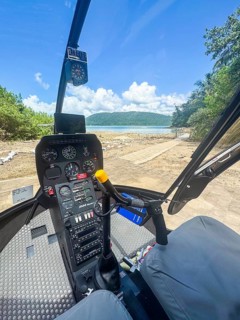 Cockpit of a two seater helicopter on ground, vertical. View to the sea in the Great Barrier Reef.