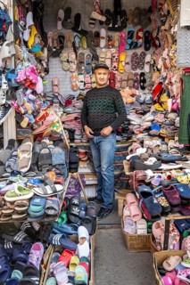 Man selling shoes, many different shoes, market stall at Osh bazaar, Bishkek, Kyrgyzstan