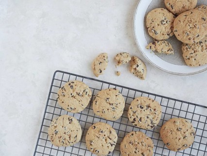 Freshly baked homemade chocolate chip cookies on a cooling rack, served in a plate and a crumbed